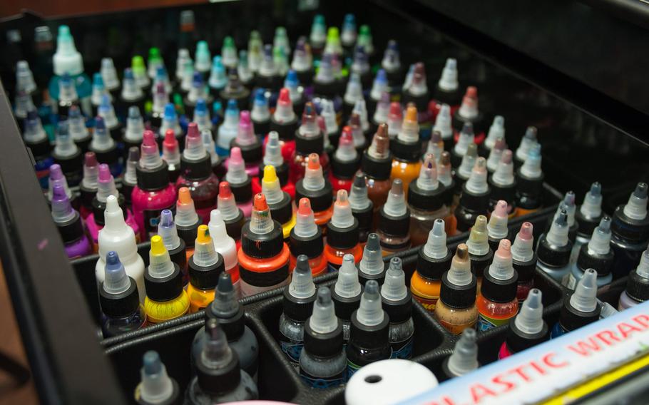 A vibrant array of ink bottles sits organized in a sleek drawer, each cap a splash of color waiting to inspire a new creation.