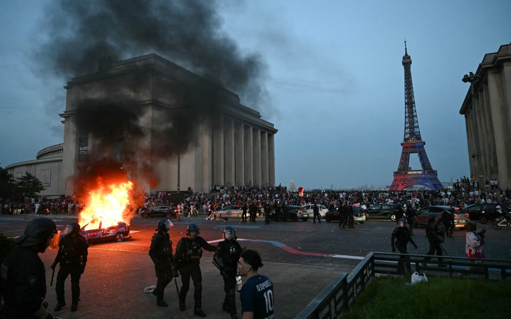 A car is set ablaze as PSG supporters celebrate their team's win in the UEFA Champions League final between Paris Saint-Germain (PSG) and Arsenal FC played in Budapest, at Place du Trocadero opposite the Eiffel Tower in Paris on May 30, 2026. (Photo by LOU BENOIST / AFP)