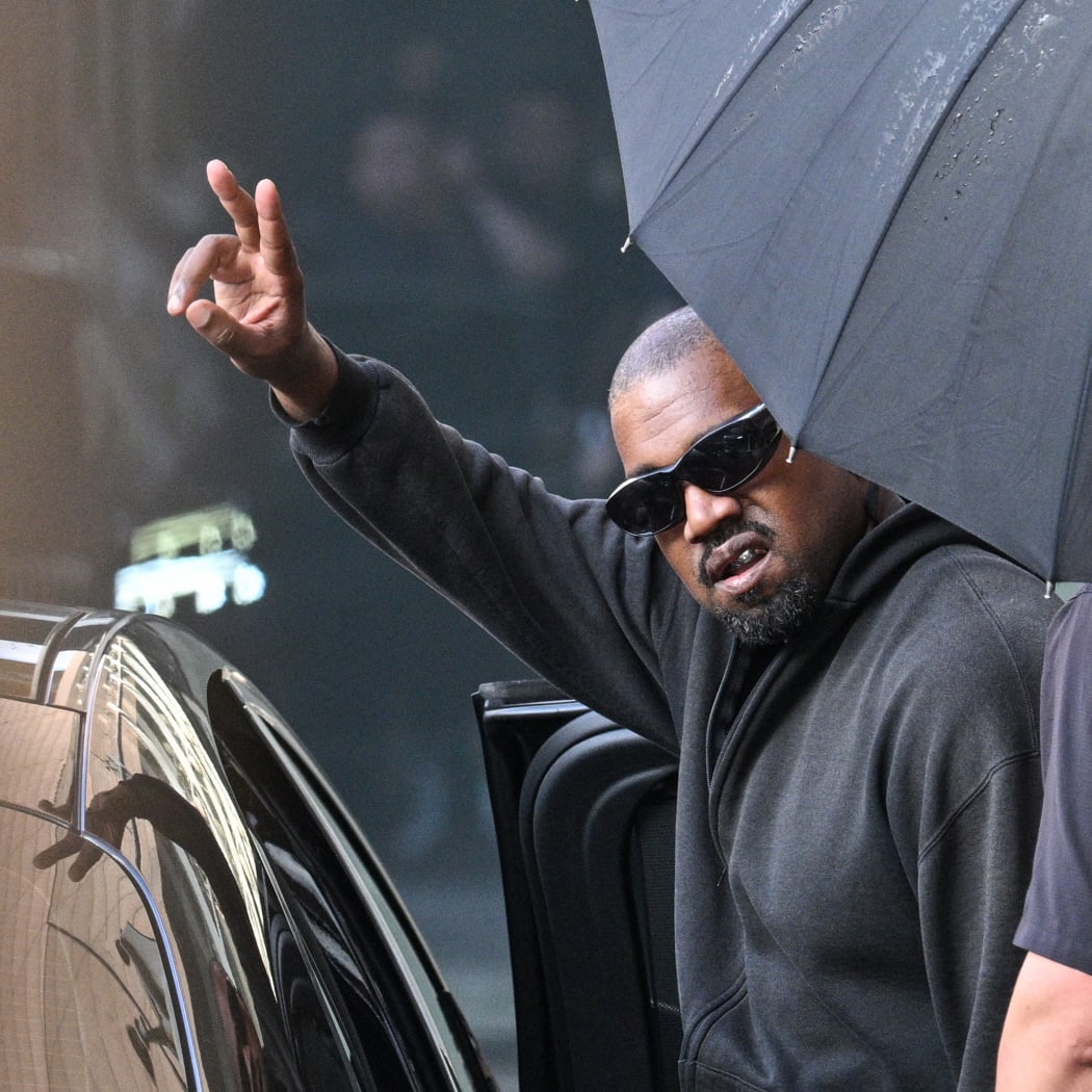 US rapper and producer Kanye West gestures upon arriving at Shanghai Pudong International Airport on July 11, 2025. One of the promoters of an annual London music festival on April 6, 2026 defended plans for Kanye West to headline it, amid a backlash over the US rapper's previous antisemitic outbursts. Disgraced 48-year-old hip-hop star West -- now known as Ye -- is due to play three nights at the Wireless Festival in the British capital in July as part of a European comeback tour. (Photo by Hector RETAMAL / AFP)