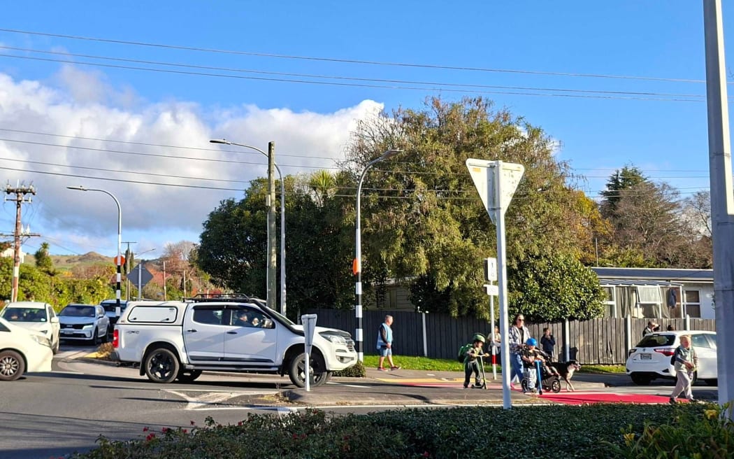 Children crossing the road at a busy Springfield Rd and Otonga Rd roundabout and crossing.