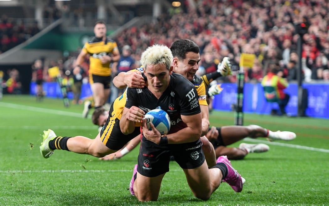 Noah Hotham of the Crusaders scores a try in the tackle of Josh Moorby.