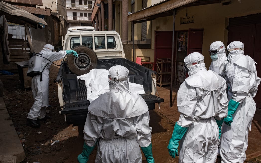 Workers from the Uganda Red Cross Society spray disinfectant during the evacuation of the body of a suspected Ebola victim in Kampala on May 26, 2026. The organisation is poised to assist the Ministry of Health in transporting suspected cases to treatment centres and conducting safe, dignified burials following confirmed positive results. This action comes after the confirmation of three additional Ebola Bundibugyo cases , raising the total to five linked to travelers from the neighbouring Democratic Republic of Congo (DRC), where an outbreak has claimed 119 lives among 904 suspected cases. The World Health Organisation has classified this outbreak in both the DRC and Uganda as a public health emergency of international concern. (Photo by Badru KATUMBA / AFP)
