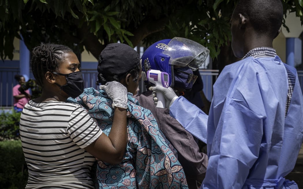 A health worker (R) measures the temperature of a patient (2nd L) suspected of having Ebola as she is transported by motorcycle taxi to Rwampara Hospital in Ituri, in the eastern Democratic Republic of the Congo, on May 26, 2026. On May 15, the DRC declared an epidemic caused by the Bundibugyo virus. There is neither a vaccine nor a specific treatment for this virus, which causes Ebola with a fatality rate of up to 50%. The WHO has issued an international health alert.
More than 900 suspected cases and 220 suspected deaths had already been recorded by the 12th day of the epidemic, according to official reports. But the true scale of the health disaster is not yet known, and international health authorities believe that the current figures are probably underestimated. (Photo by Glody MURHABAZI / AFP)