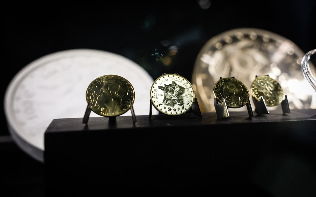 Marianne-Or gold coins bullions displayed at La Monnaie de Paris in Paris on May 21, 2026. The Paris Mint said on May 26, 2026, that it would soon start selling solid-gold coins for investment, the first since it quit making Napoleons and Louis a century ago. Four versions of the new Marianne coins will go on sale June 16, ranging from one-tenth of an ounce (3.1 grams) to a full ounce (31.1 grams). (Photo by SIMON WOHLFAHRT / AFP)
