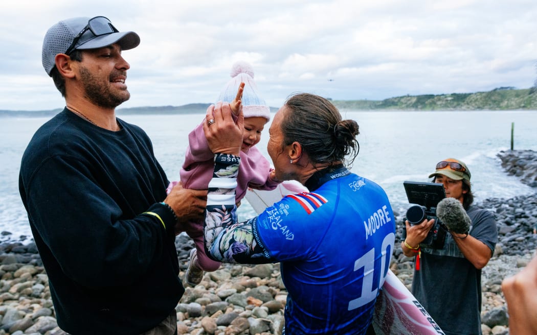Five-time World Surf League champion Carissa Moore of Hawaii greets her daughter after winning her semifinal at the New Zealand Pro at Raglan, May 24, 2026.  (Photo by Rambo Estrada/World Surf League)