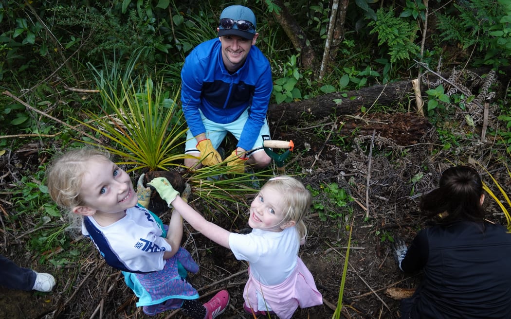 Hillsborough sisters Emily, 9, and Juliette Darlington, 6, show their dad how planting’s done.