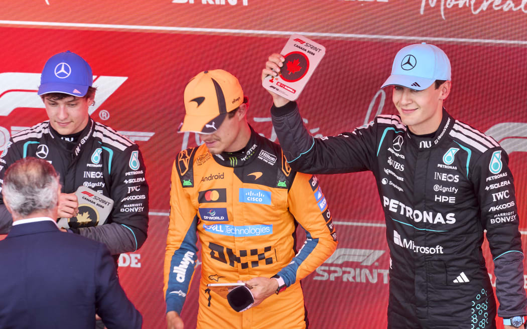 Mercedes driver George Russell, right, shows his plaque after winning the Canadian Grand Prix sprint race, with second placed Lando Norris, centre, and third-placed driver Kimi Antonelli, left, in Montreal, Canada, on May 23, 2026. (Photo by Geoff Robins / AFP)