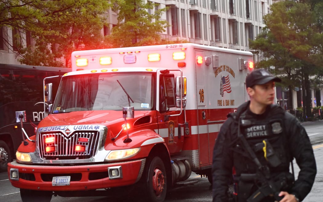 An armed Secret Service agent is seen next to an ambulance near the White House in Washington, DC, on May 23, 2026. Police and security forces swarmed the area around the White House on the evening of May 23 after reports of shots fired, AFP journalists said. US President Donald Trump was at the White House at the time as he worked to negotiate a deal with Iran. (Photo by Alex WROBLEWSKI / AFP)