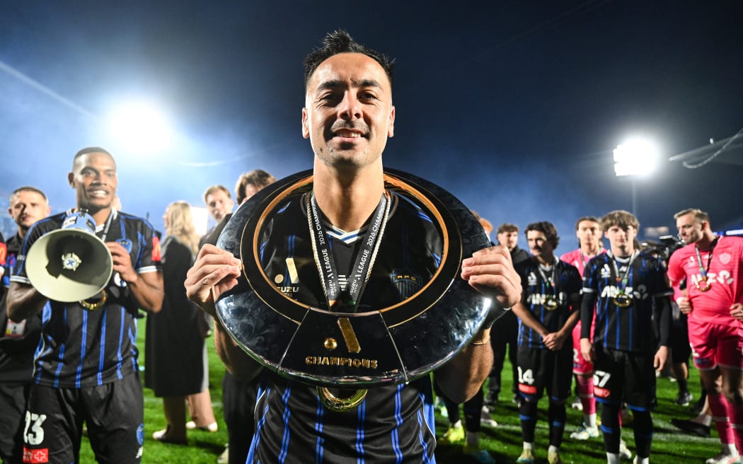 Cam Howieson of Auckland FC celebrates with the A-League trophy.
