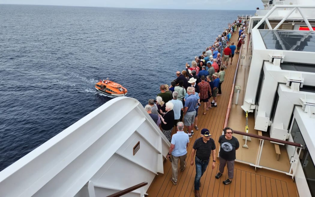 Passengers aboard the Viking Neptune wave to crew members who explored the area on a tender.
