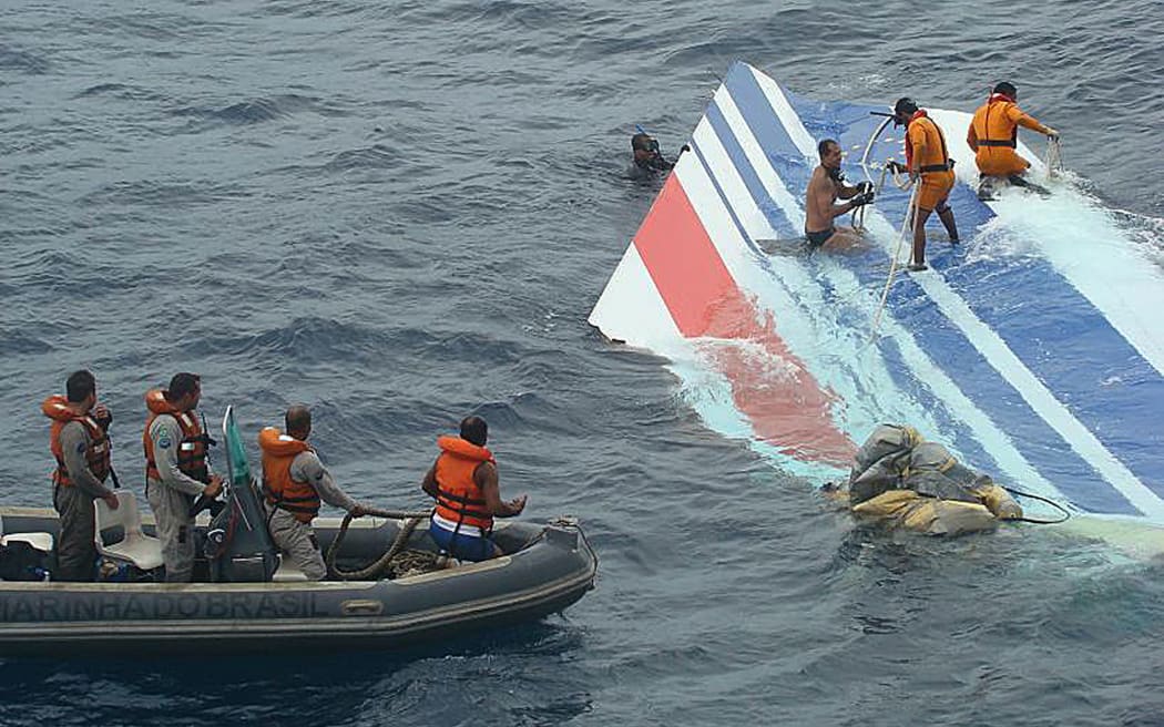 Handout picture released June 8, 2009 by the Brazilian Navy showing divers recovering a huge part of the rudder of the Air France A330 aircraft lost in midflight over the Atlantic ocean June 1st. Seventeen bodies have been recovered from the Atlantic where an Air France jet came down a week ago as French submarines head to the remote zone in search of the black boxes. The remains, and dozens of structural components from the plane also plucked from the waves, were expected to arrive in the Brazilian archipelago Fernando de Noronha on Tuesday.