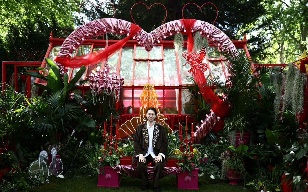 Designer James Whiting poses for a picture in his exhibit "Aphrodite's Hothouse" on the press day ahead of the 2026 RHS Chelsea Flower Show in London on May 18, 2026. Shaking up the normally genteel world of gardening, Aphrodite's Hothouse is described on the RHS website as "the ultimate pleasure garden ... lush, fragrant and just a little bit naughty". (Photo by Henry Nicholls / AFP)