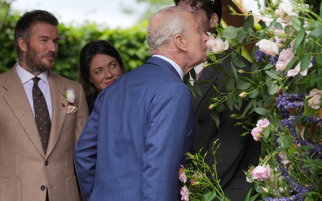 Former England footballer David Beckham (L) and designer Frances Tophill react as Britain's King Charles III smells a Sir David Beckham Rose, by David Austin Roses, at the 2026 RHS Chelsea Flower Show in London on May 18, 2026. (Photo by Yui Mok / POOL / AFP)