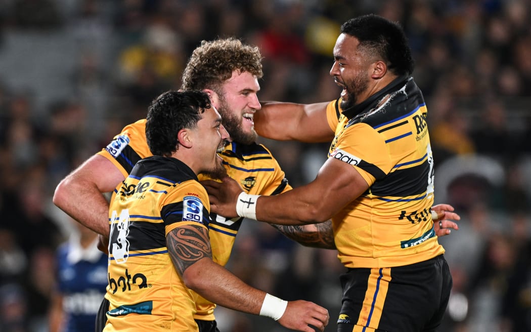Warner Dearns of the Hurricanes celebrates his try with Billy Proctor and Asafo Aumua.
