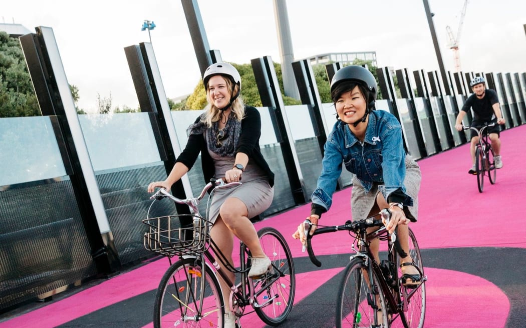 Cyclists cross Te Ara I Whiti - The Lightpath, one of Auckland’s most recognisable public spaces.