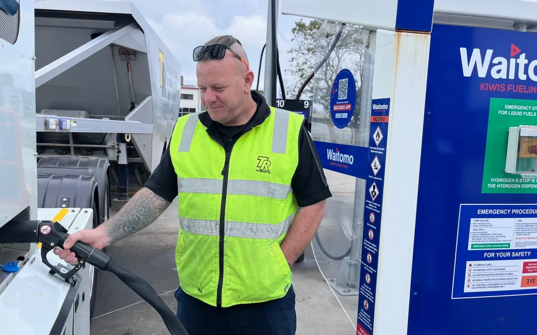 TR Group driver trainer Paul Fair holds a refuelling nozzle at a hydrogen refuelling stop.