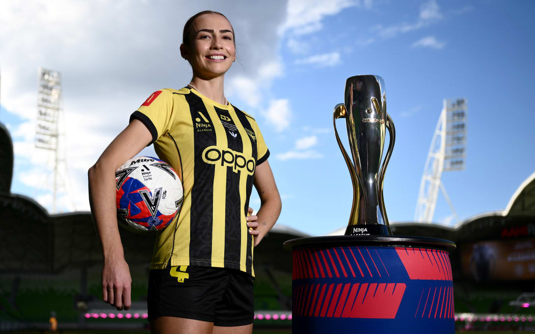 Mackenzie Barry of the Wellington Phoenix poses with the A-League women trophy at AAMI Park, in Melbourne.