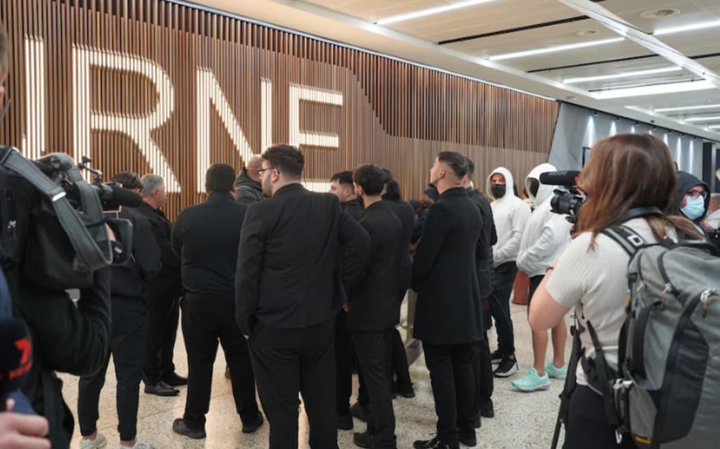 A group of men waited at international arrivals at Melbourne Airport after the flight landed, but did not speak to media.