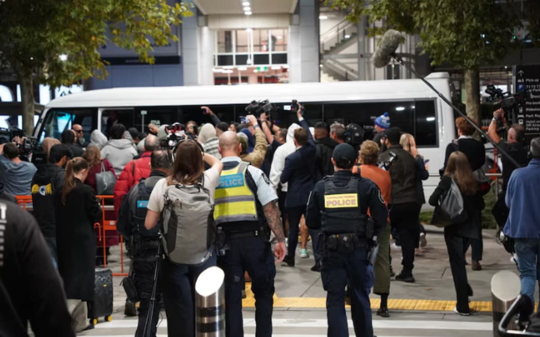 Police were on hand as the media and the men escorting the women and children jostled their way out of Melbourne Airport.