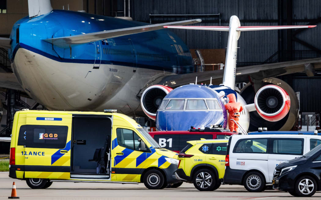 This photograph shows a person in a white hazmat suit (Centre L) disembarking a Bombardier Challenger 605 medical aircraft allegedly carrying some of the passengers believed to be infected with hantavirus from the cruise ship MV Hondius, before being escorted to an ambulance at Schiphol Airport in Amsterdam on May 6, 2026. A plane that left Cape Verde following the evacuation of a cruise ship hit by the hantavirus landed in Spain's Canary Islands on May 6, while a second flight headed for the Netherlands. (Photo by Jeffrey Groeneweg / ANP / AFP) / Netherlands OUT