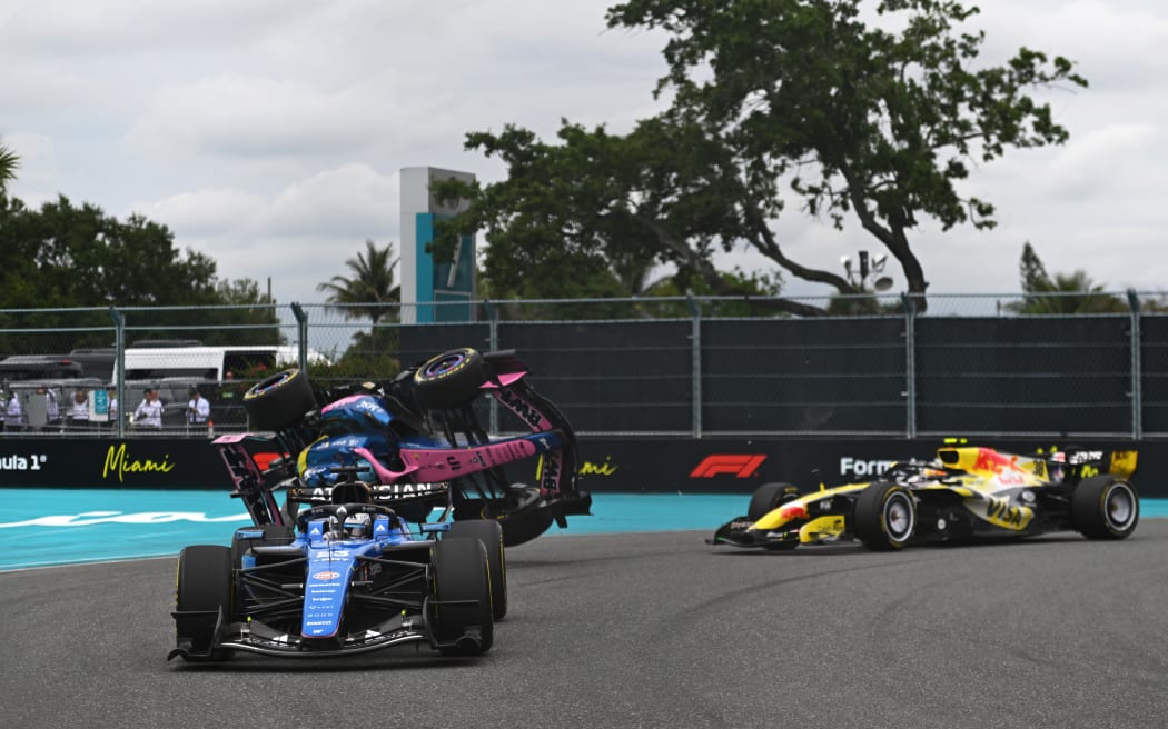 The Alpine car of Pierre Gasly flips following a collision with Liam Lawson's Racing Bulls car (R) at the Miami Grand Prix.