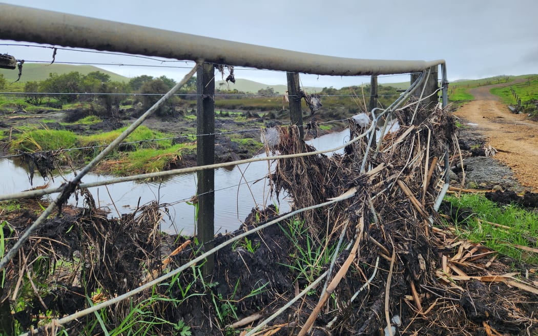 A fence covered in flood debris