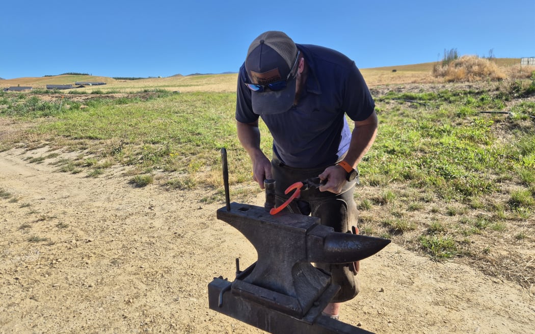 Bruce shapes the hot horse shoe against a portable anvil attached to his ute.