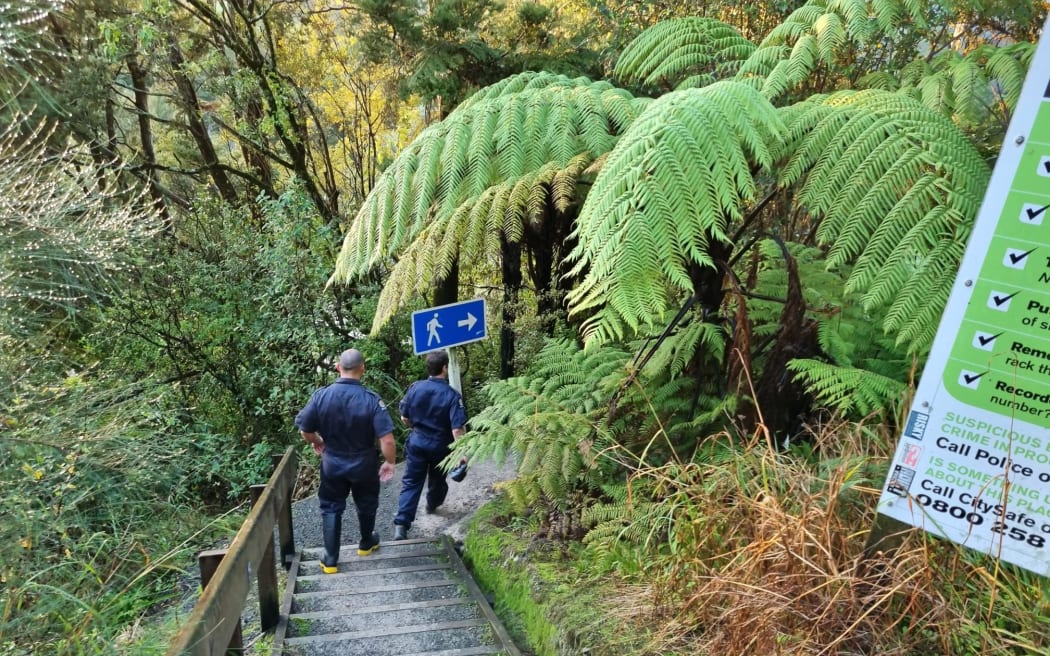Police walk down steps towards the Abbey Caves, Whāngarei, after searchers looking for a Whangārei Boys' High School student recovered a body.