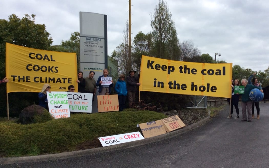 Protestors hold large yellow anti-mining banners at the gates of Bathurst Resources' opencast coal mine at Rotowaro near Huntly, Waikato