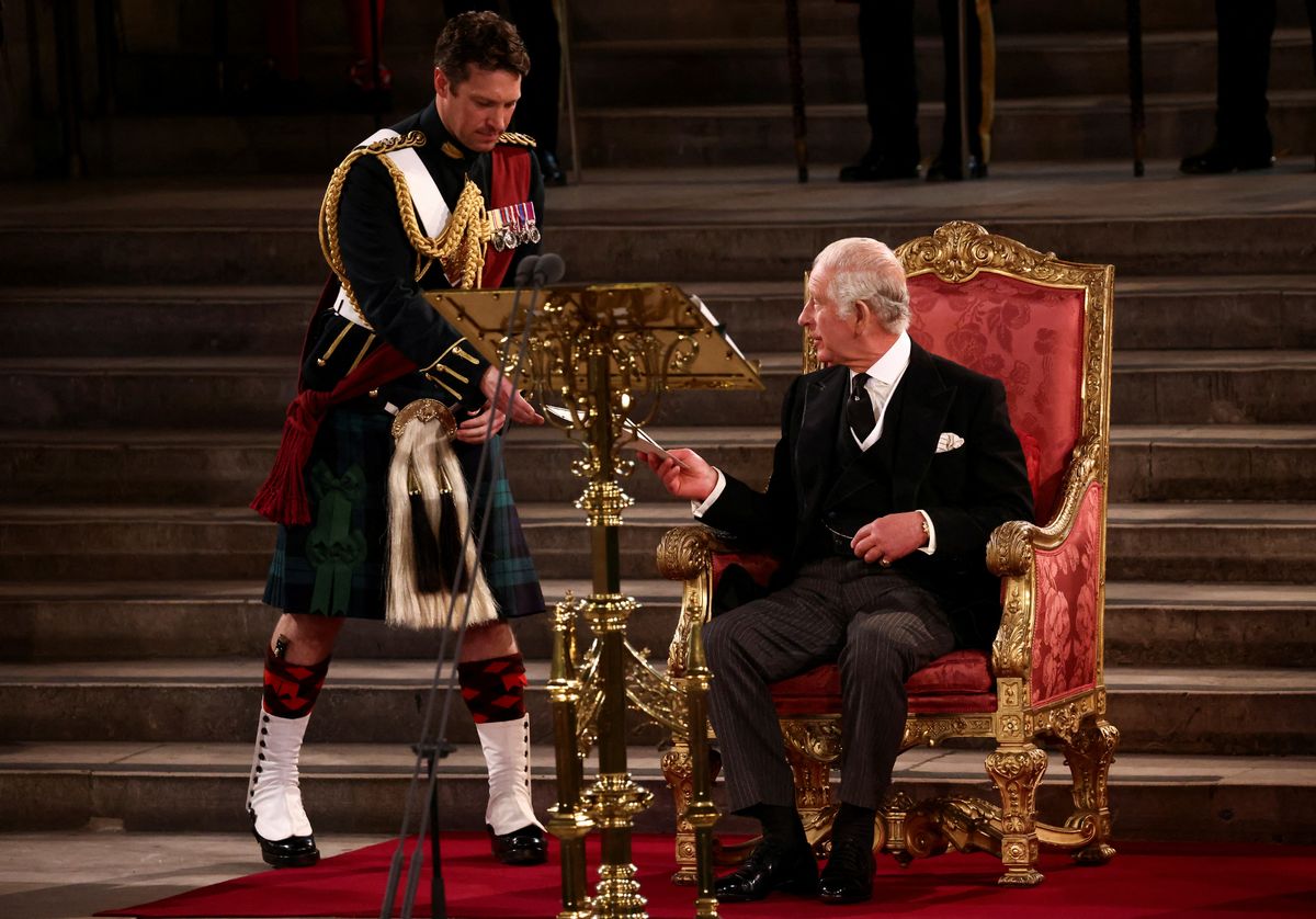 The King with his equerry as he addresses Parliament after his accession