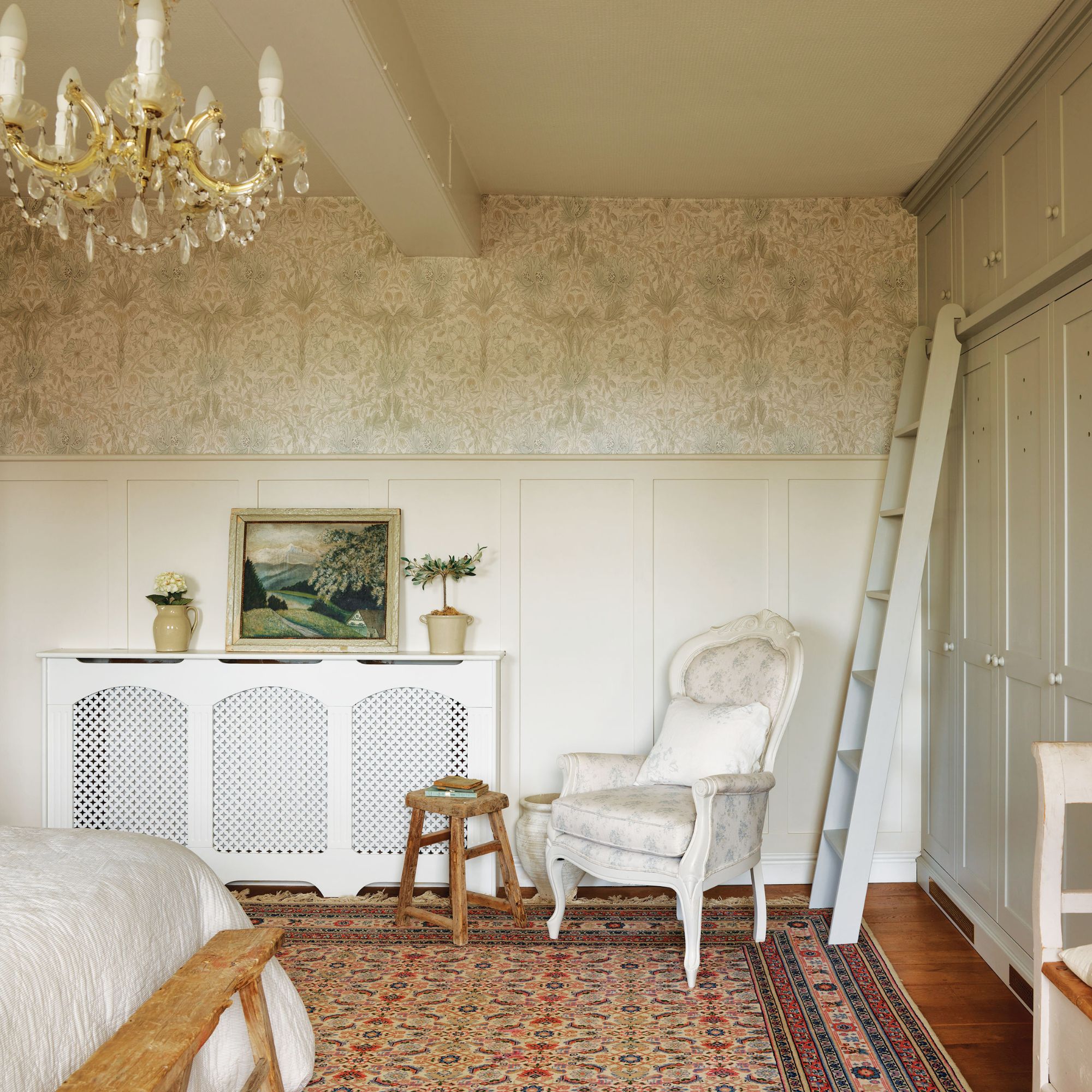 Main bedroom - cottage room with radiator cover, large pasely rug and chandelier