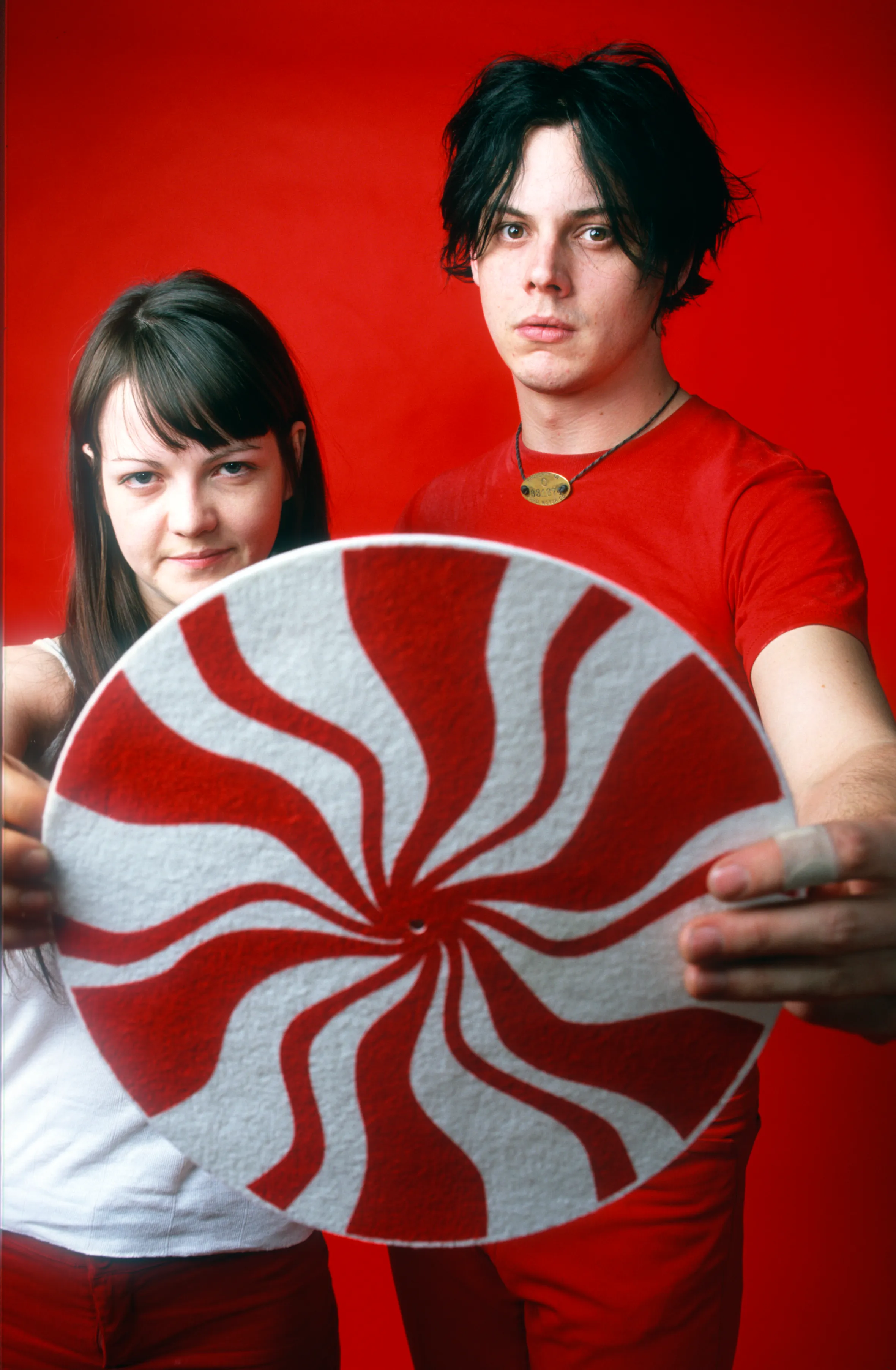 Jack and Meg White of The White Stripes hold a red and white swirled disc.