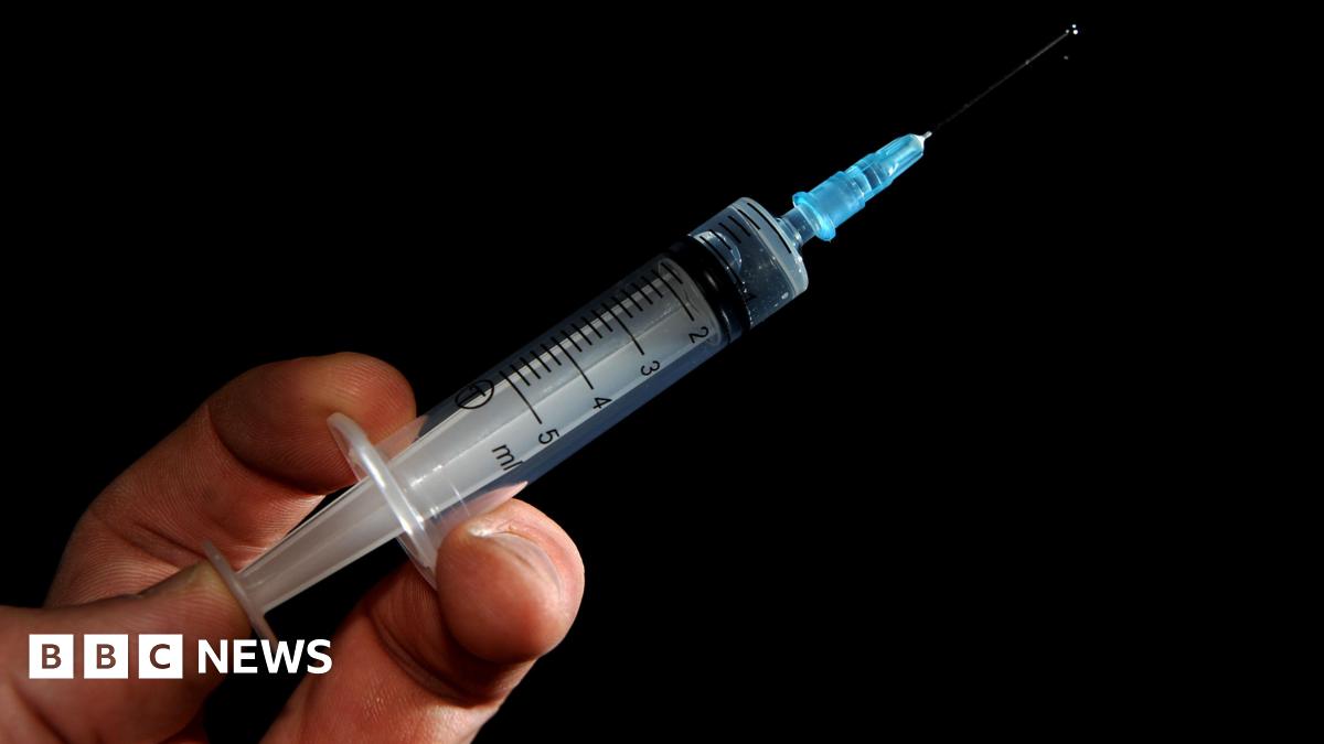 A generic image of a needle in a person's hand