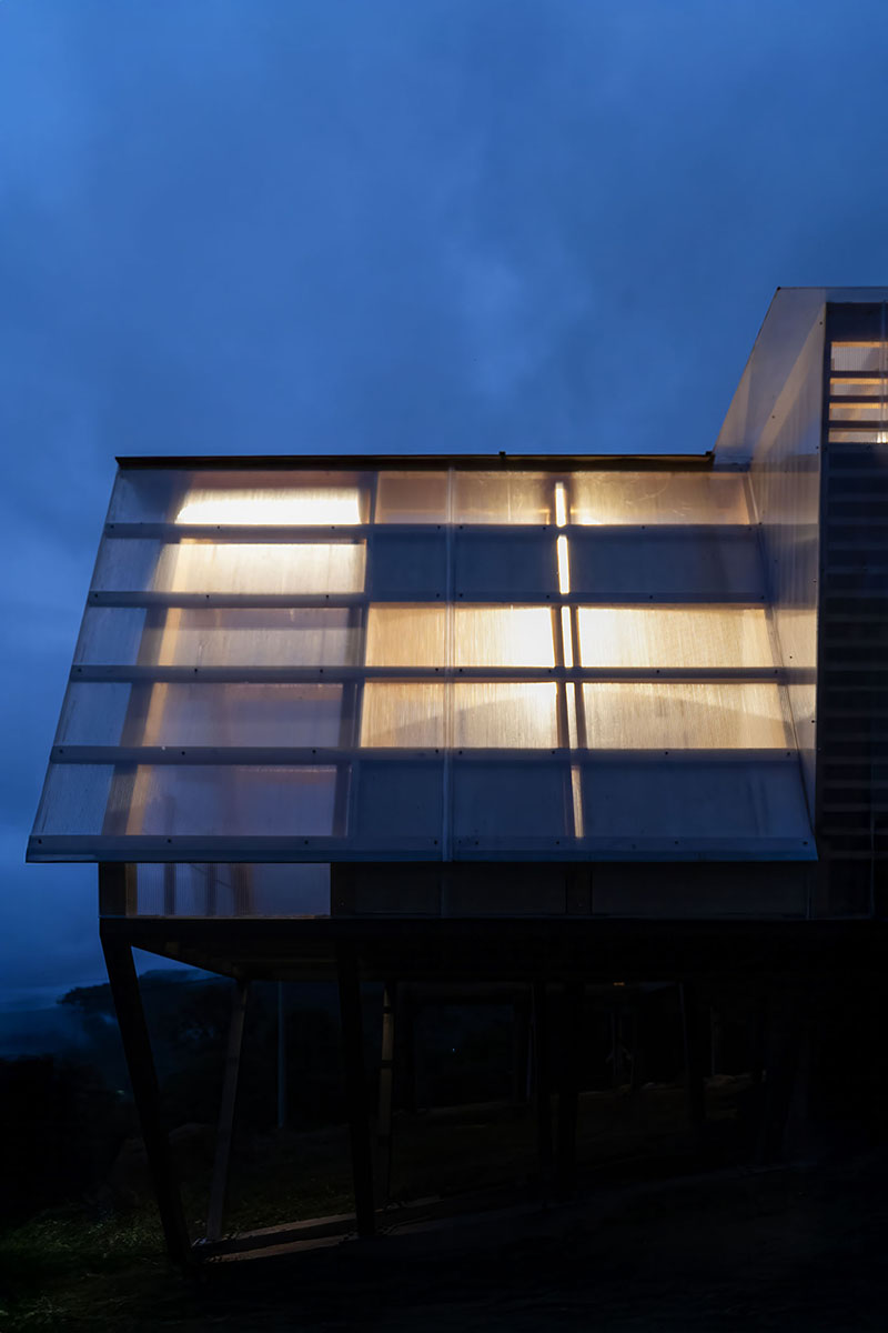 translucent polycarbonate skin envelopes triangular shelter elevated on stilts in ecuador - 10