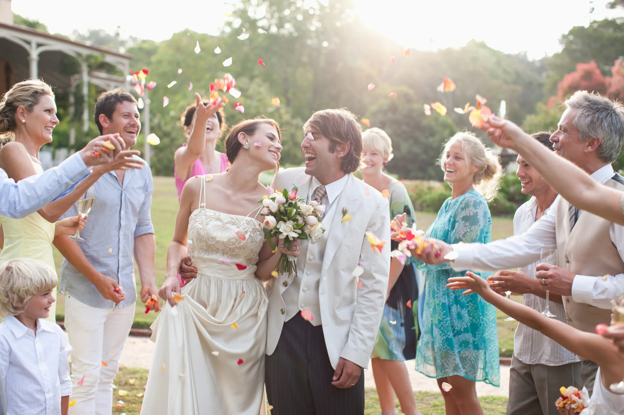 Guests throwing rose petals on the bride and groom.