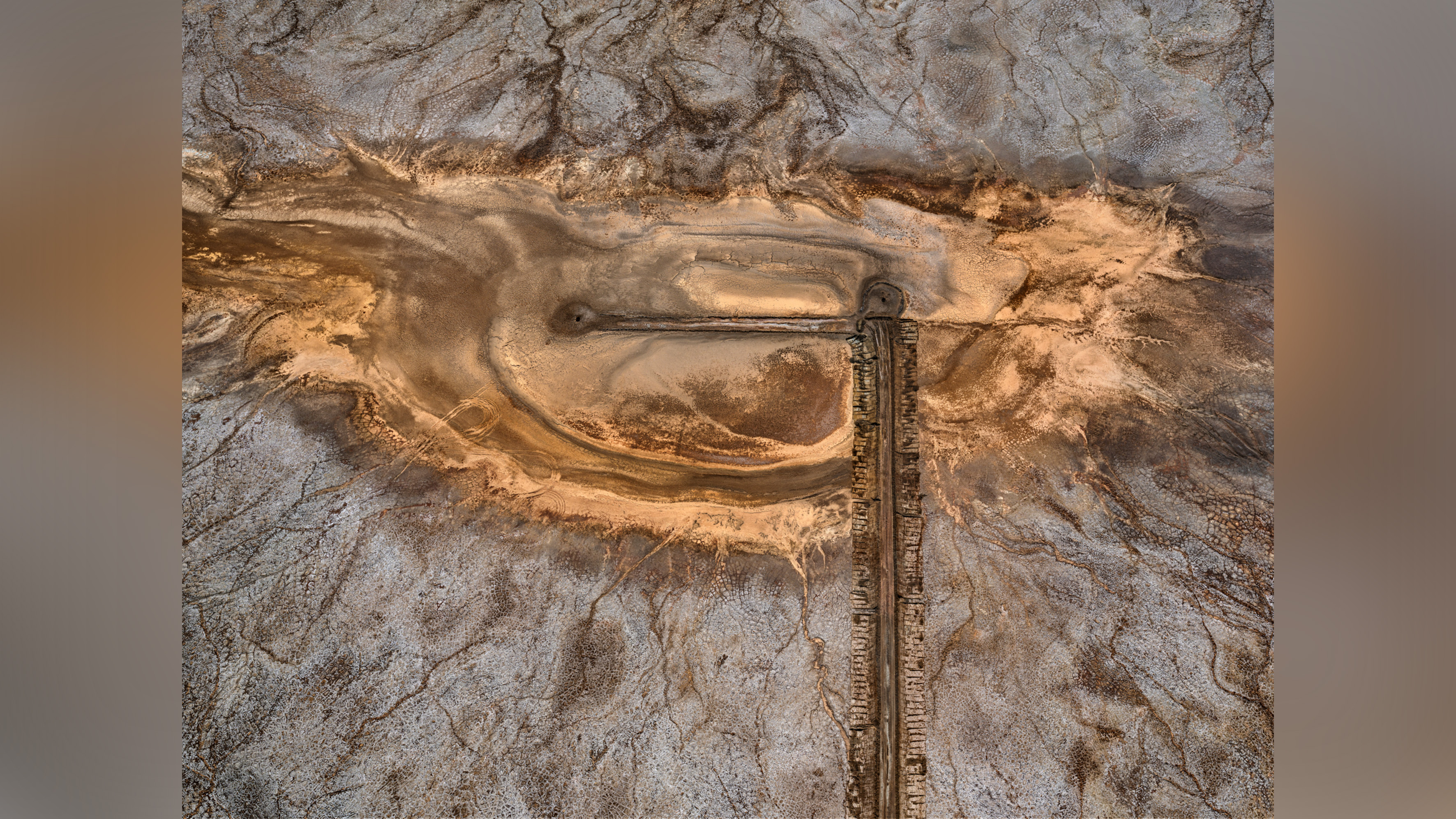 Colorful patterns in landscape produced by industrial mineral extraction.