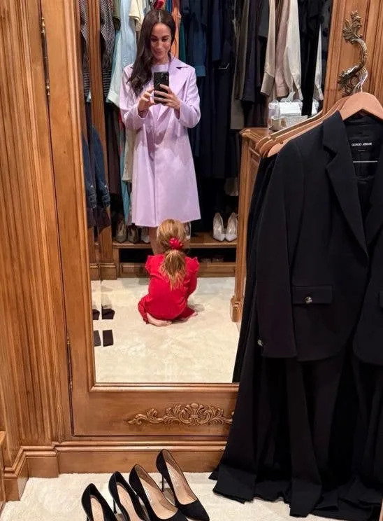 Meghan Markle taking a selfie as Princess Lilibet kneels at her feet