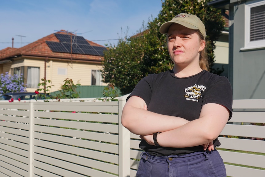 a woman with her arms folded in a suburban street