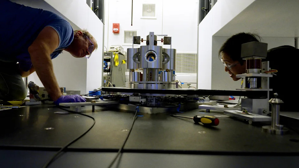 Stephan Schlamminger (left) and colleague Vincent Lee examine the torsion balance they used to measure the gravitational constant, Big G.