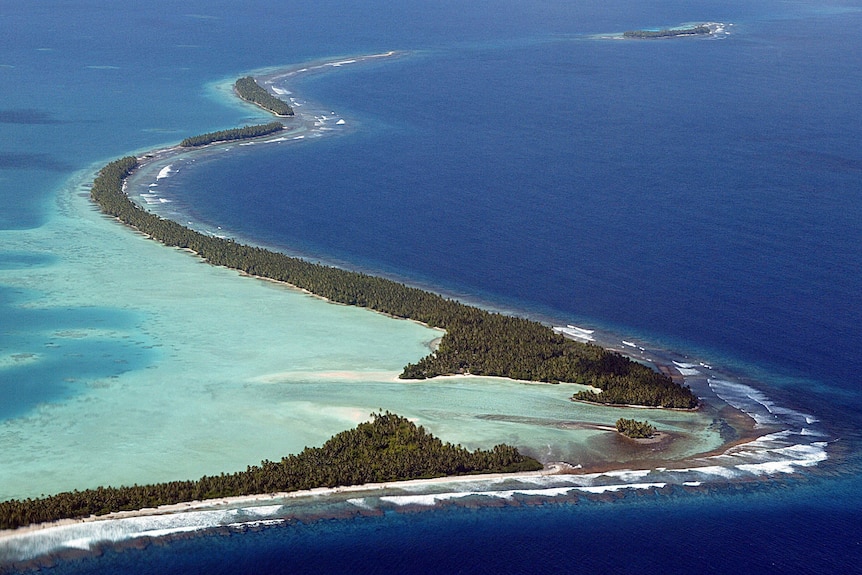 An aerial shot of Tuvalu's winding thin beaches cutting across the Pacific ocean.