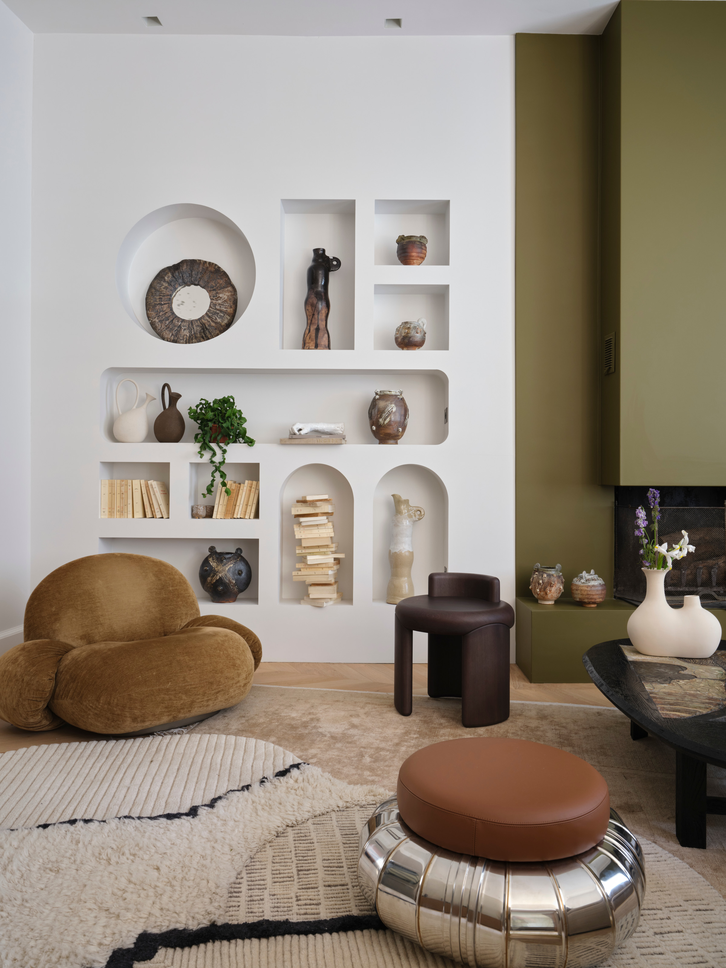 Snug with shelving carved into wall in geometric and arched shapes