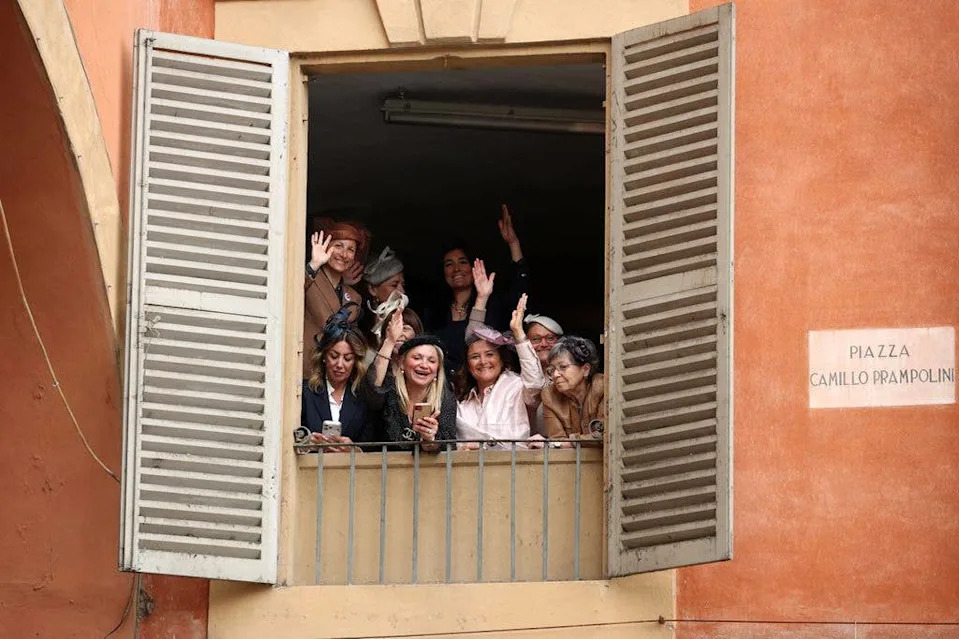 People gather in a window ahead of the arrival of Catherine, Princess of Wales on the first day of her visit to Reggio Emilia on May 13, 2026 in Reggio Emilia, Italy