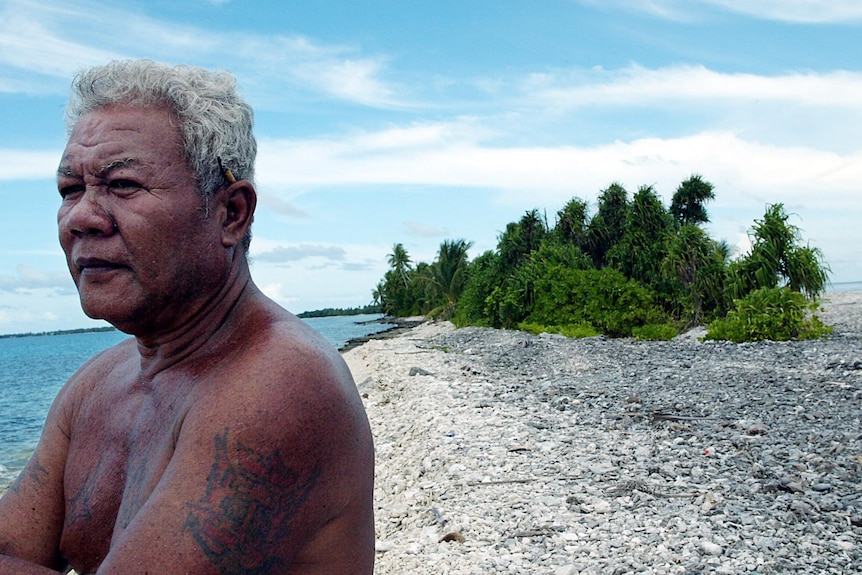 A fisherman looks out to sea at high tide from the shores of Funafuti Atoll.