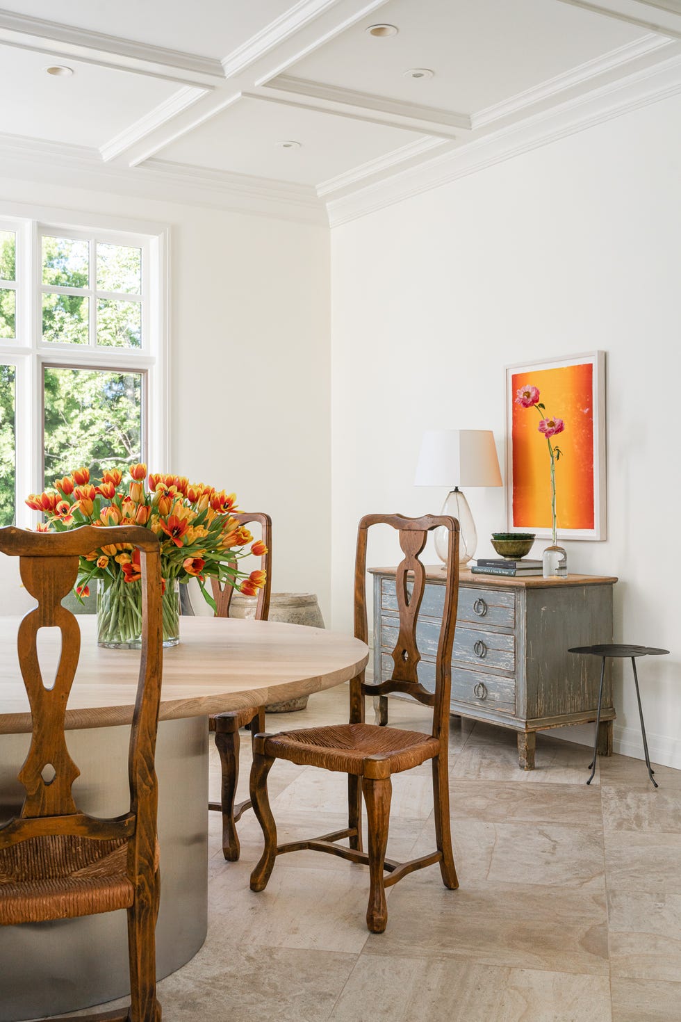 Dining area featuring a wooden table and chairs with a floral arrangement.