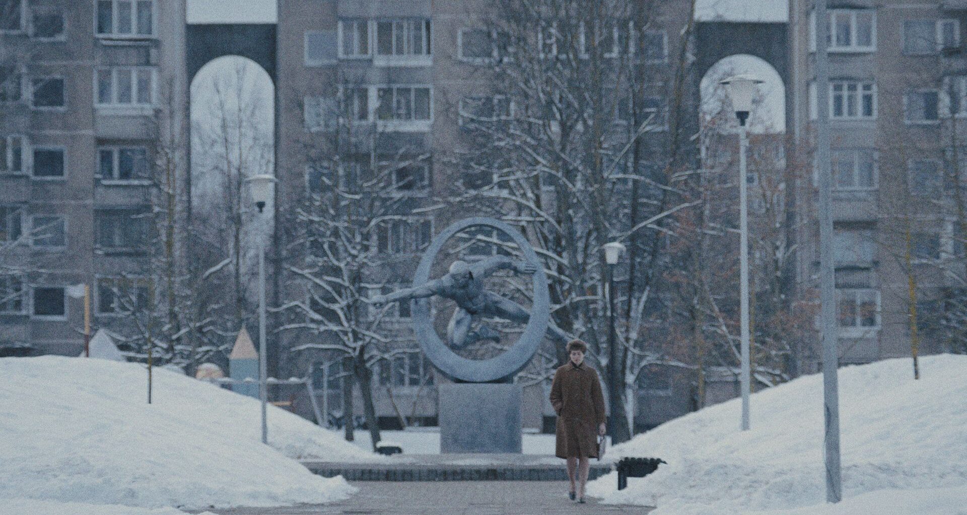 a woman walking through a snowy city scene
