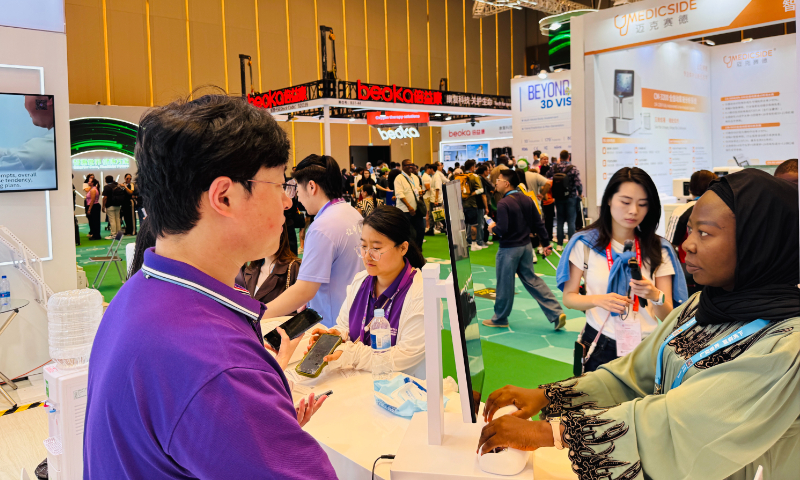 A foreign buyer (first from right) tries AI pulse diagnosis, along with facial and tongue analysis, at the smart healthcare zone of the 139th Canton Fair in Guangzhou, South China’s Guangdong Province, on May 2, 2026. Photo: Chi Jingyi/GT