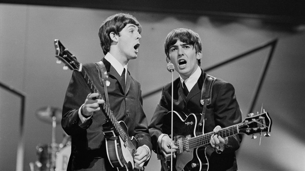 British musicians Paul McCartney and George Harrison (1943 - 2001) of the Beatles performing on stage at the London Palladium, UK, 13th October 1963.