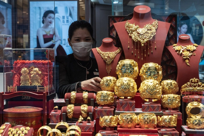 A worker is organizing the jewelry inside a display window at a jewelry store in Hong Kong, China, on December 7, 2023. Photo by NurPhoto via AFP