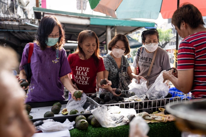 Customers browse avocados at a morning wet market in Bangkok, Thailand, on October 19, 2025.  Photo by NurPhoto via AFP