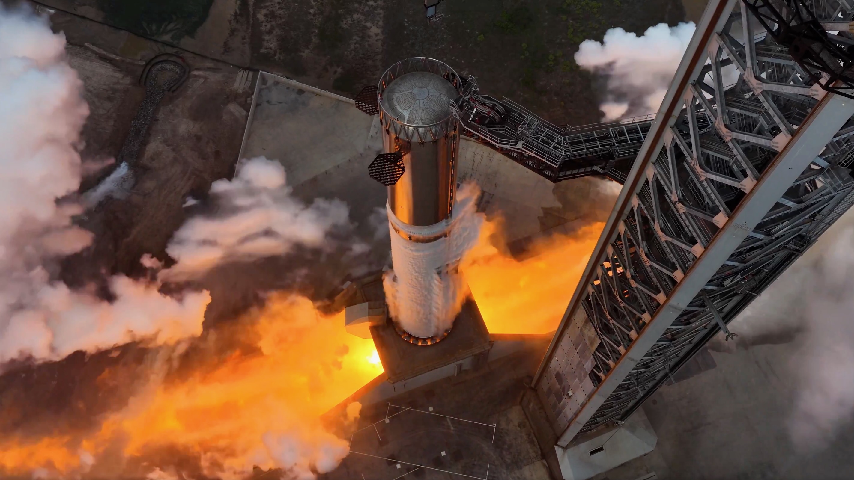 overhead view of a rocket firing its engines on the pad during a test